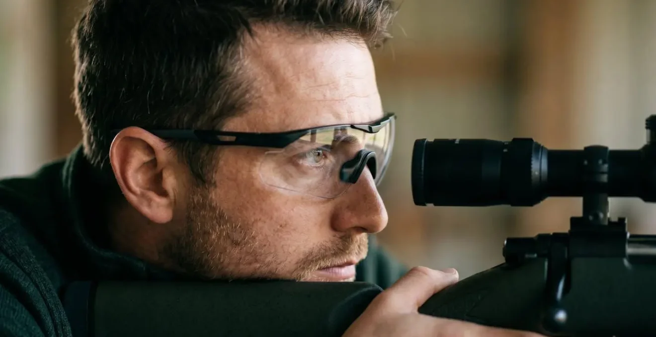 Vue de profil d'un tireur avec lunettes spécialisées visant dans une lunette de tir